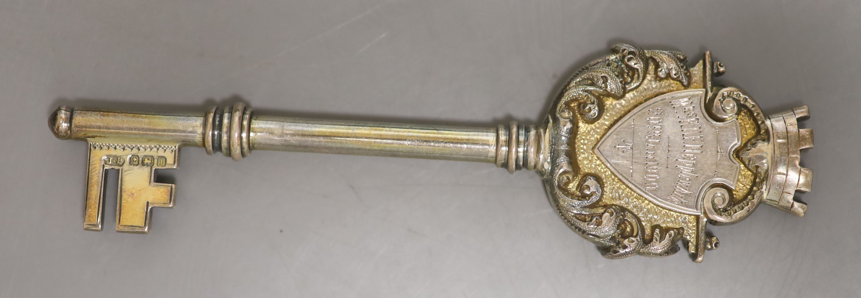 A cased Edwardian parcel gilt silver presentation key, Birmingham, 1908, 10.2cm and a late Victorian silver medallion.